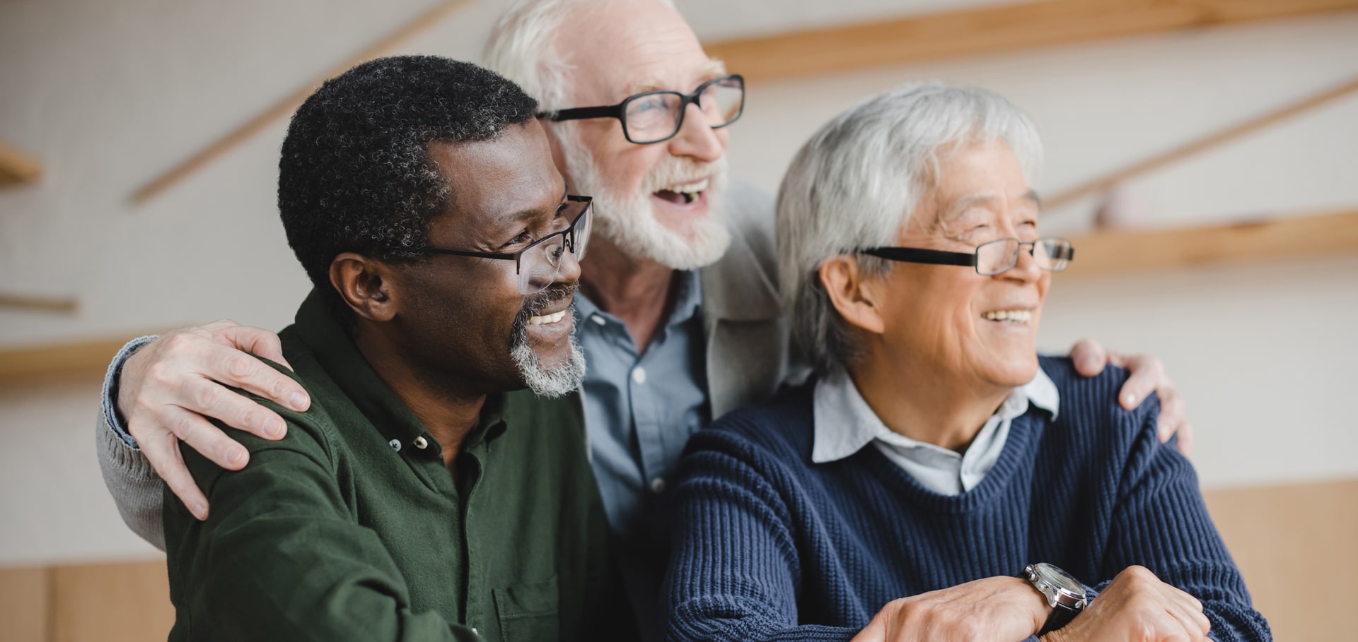 Three elderly gentlemen laughing and smiling